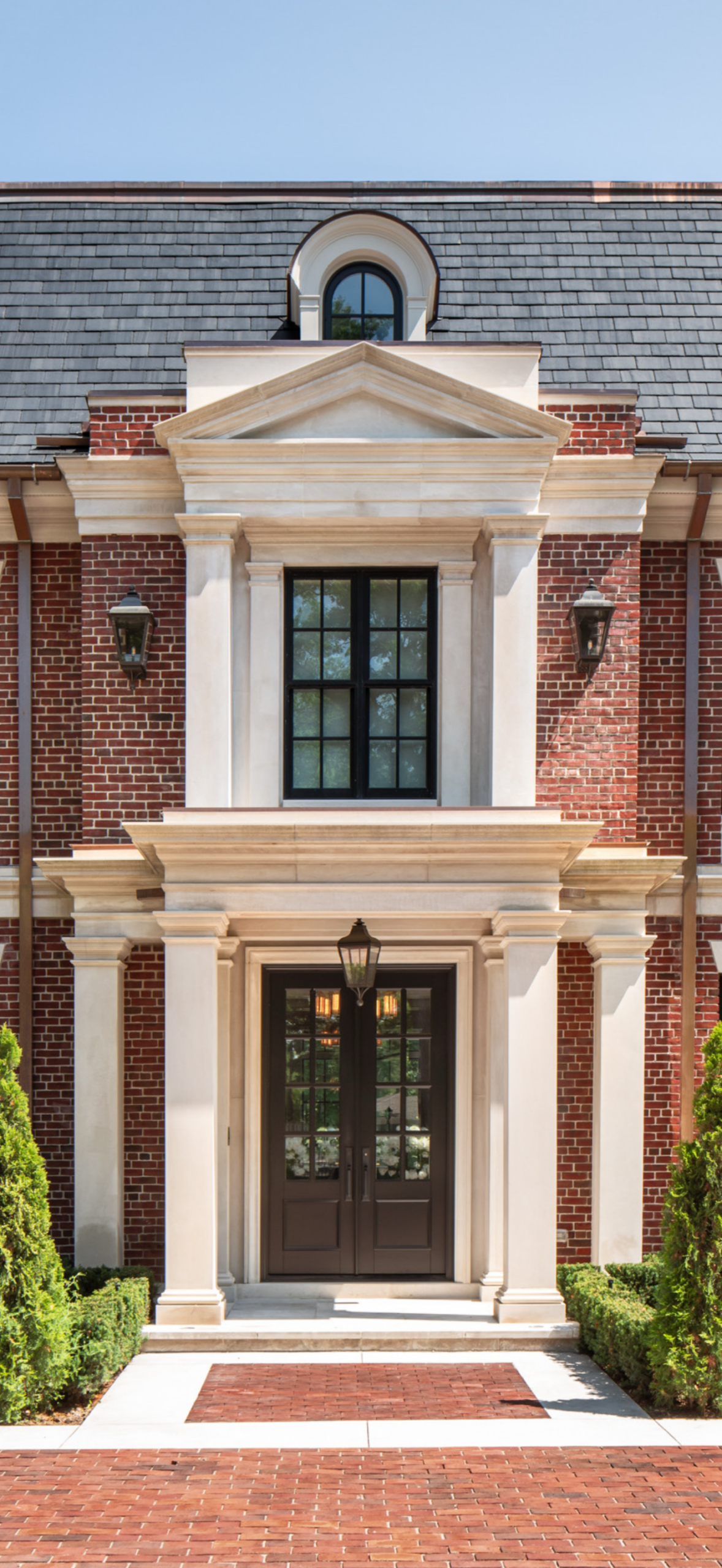 Symmetrical brick mansion entrance with columns and lantern