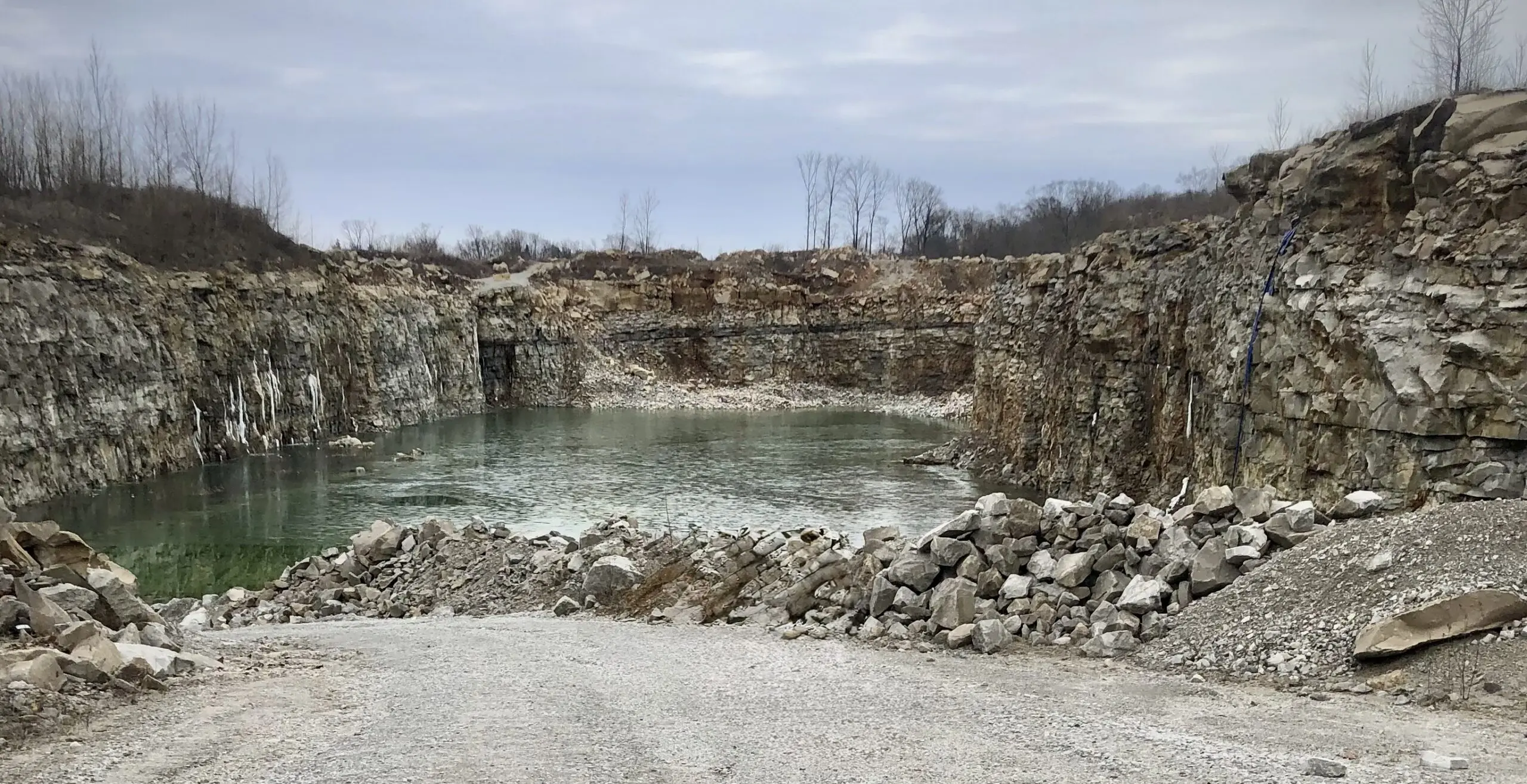 Abandoned limestone quarry filled with green water
